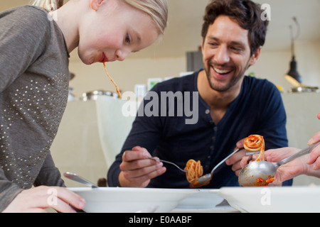 Metà uomo adulto e la famiglia di mangiare un pasto di spaghetti Foto Stock