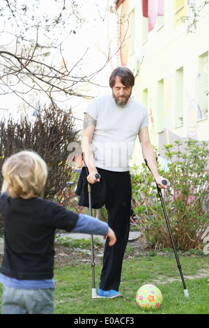 Disabilitato il padre con il figlio a giocare a calcio Foto Stock