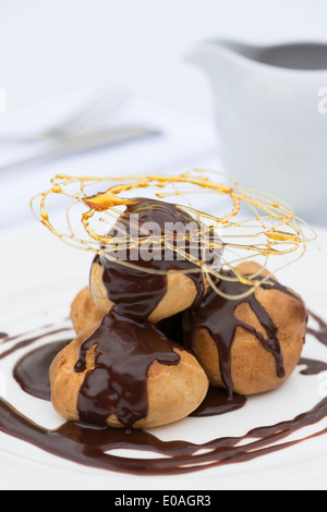 Un profiterole, soffio di crema o choux à la crème. Un francese dessert bignè sfera farcito con panna montata. Foto Stock