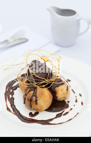 Un profiterole, soffio di crema o choux à la crème. Un francese dessert bignè sfera farcito con panna montata. Foto Stock