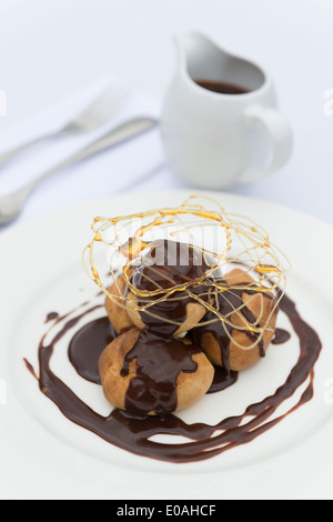 Un profiterole, soffio di crema o choux à la crème. Un francese dessert bignè sfera farcito con panna montata. Foto Stock