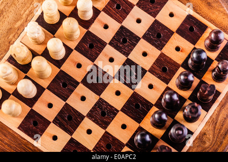 Un piccolo e di legno scacchiera con pezzi di scacchi Foto Stock