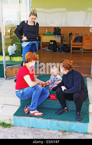 Un giorno con parachutist in aeroporto. Il bambino con la madre-paracadutista e lei amiche vicino a una classe educativo riproduce. Foto Stock