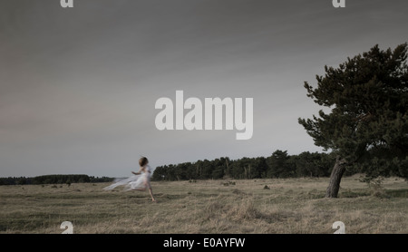 In Germania, in Baviera, Froettmaning Heath, giovane donna che indossa un abito in tulle e in esecuzione Foto Stock