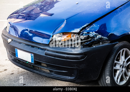 Una piccola auto blu danneggiato nella parte anteriore luci di sinistra Foto Stock