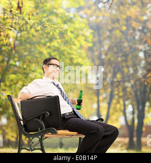 Imprenditore prendendo una pausa nel parco con una birra Foto Stock