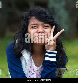 Giovane ragazza che mostra il segno della vittoria Bali Indonesia Foto Stock