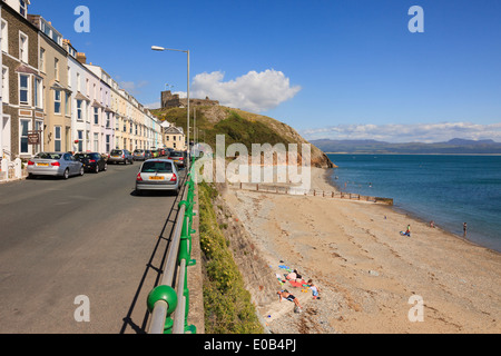 Vista lungo la strada lungomare per le rovine del castello di spiaggia di cui sopra nella località balneare di Criccieth, Lleyn Peninsula Gwynedd North Wales UK Foto Stock