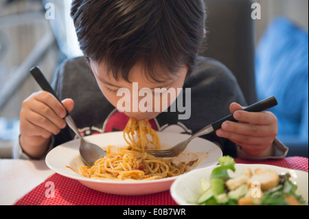 Ragazzo mangiare spaghetti Foto Stock