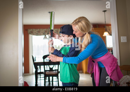 Madre figlio di insegnamento per tenere una mazza da baseball Foto Stock