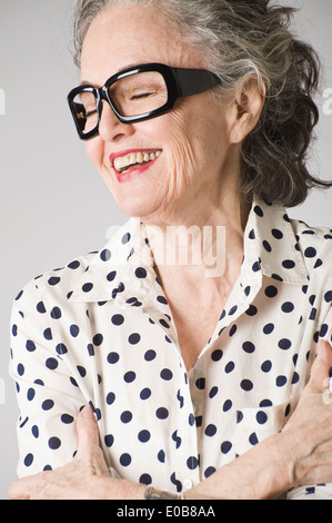 Ritratto di donna senior, con le braccia incrociate, ridendo Foto Stock