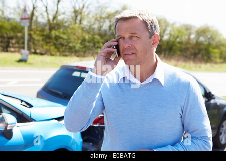 Autista rendendo telefonata dopo incidente stradale Foto Stock