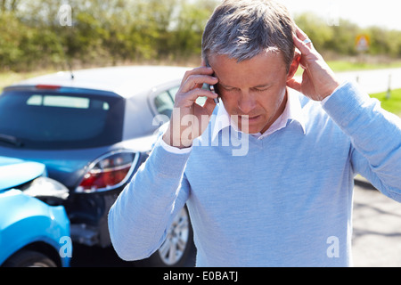 Autista rendendo telefonata dopo incidente stradale Foto Stock