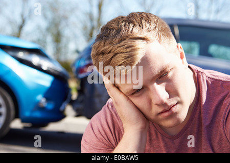 Driver femmina rendendo telefonata dopo incidente stradale Foto Stock