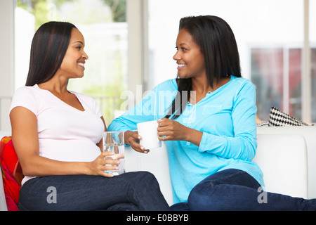 Donna incinta in visita ad un amico Home Foto Stock