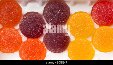 Round jelly spolverati con zucchero in una scatola di plastica closeup. Foto Stock