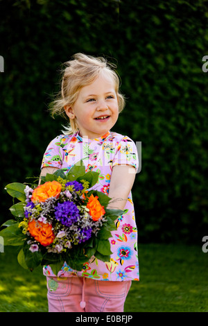 Un bambino piccolo con bouquet. Presente per la Festa della mamma, Kleines tipo mit Blumenstrauss. Geschenk fuer Muttertag Foto Stock