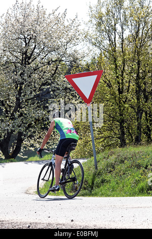 Boss allenatori fitness e rigidi bicicletta su una ruota da corsa, Senior Fitness trainiert und faehrt Fahrrad auf einem Rennrad Foto Stock