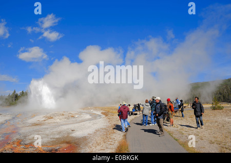 I turisti a guardare l'eruzione di Daisy Geyser, Upper Geyser Basin, il Parco nazionale di Yellowstone, Wyoming USA Foto Stock