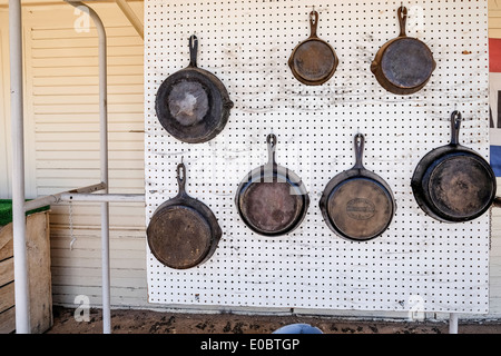 Vecchio ghisa skillets, per la vendita, appendere su un bordo esterno di un mercato delle pulci in Oklahoma City, Oklahoma. Foto Stock