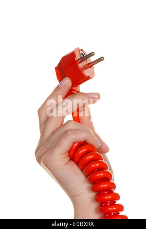 La mano di una donna che si mantiene un flusso di rosso spina., Die mano einer Frau haelt einen roten Stromstecker. Foto Stock