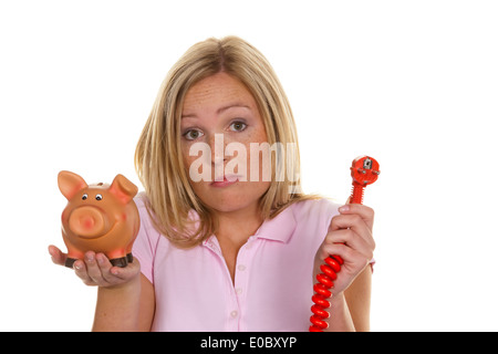Una giovane donna con un salvadanaio e un flusso tappo. Foto simbolico dei costi per l'energia Foto Stock