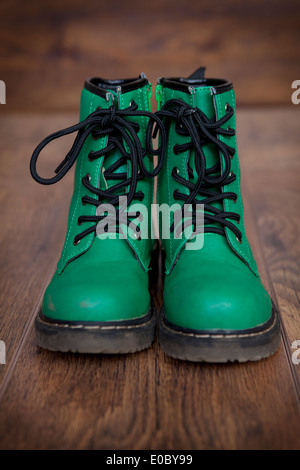 Una coppia di pizzo verde-up stivali su un pavimento di legno. Foto Stock