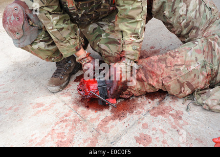 Combattimento militare applicazione Tourniquet C-A-T bean utilizzato dalla British Army medics su un esercizio di formazione prima di bean distribuito Foto Stock