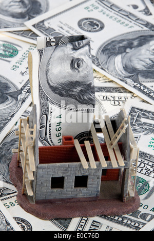 Una shell house. Finanziamento con il dollaro di banconote, Ein Rohbau Haus. Finanzierung mit Dollar Geldscheinen Foto Stock