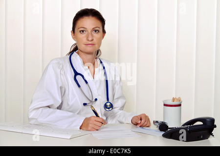 Giovane medico nella sua pratica medica presso il desk, Junge aerztin in ihrer Arztpraxis am Schreibtisch Foto Stock