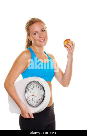 Giovane donna con scale di personali e Apple. Dieta di successo, Junge Frau mit Personenwaage und Apfel. Erfolgreiche Diaet Foto Stock