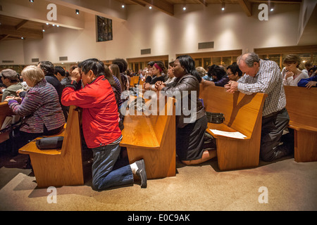 La Congregazione si inginocchia in preghiera durante la Santa Messa nella Basilica di San Timoteo della Chiesa Cattolica, Laguna Niguel, CA Foto Stock