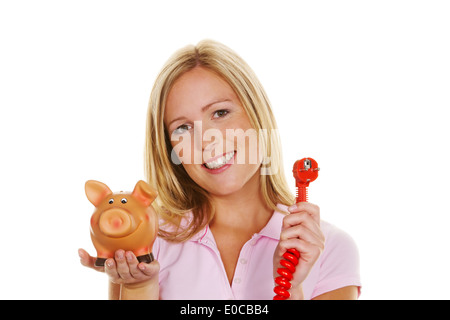Una giovane donna con un salvadanaio e un flusso tappo. Foto simbolico costi per energia, Eine junge Frau Mit einem Sparschwein und ein Foto Stock