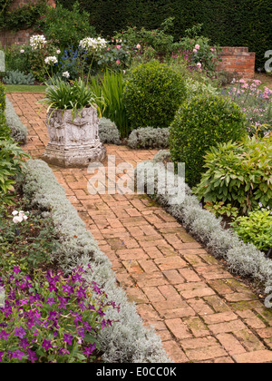 Vecchio rosso mattone percorso e letti formale in Coton Manor Gardens, Coton, Northamptonshire, England, Regno Unito Foto Stock