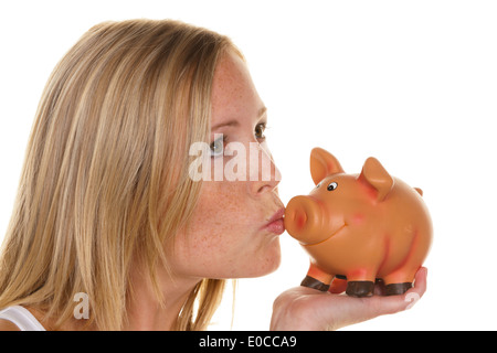 Una giovane donna consente di risparmiare denaro e di monete in euro per il futuro. Precauzione e salvare., Eine junge Frau spart Geld und Muenzen fuer die Zukunf Foto Stock