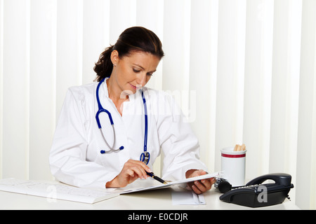 Giovane medico nella sua pratica medica presso il desk, Junge aerztin in ihrer Arztpraxis am Schreibtisch Foto Stock