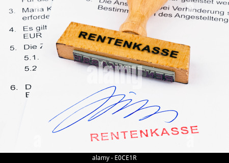 Un francobollo di legno si trova su un documento. Etichetta fondo pensione, Ein Stempel aus Holz liegt auf einem Dokument. Aufschrift Rentenkasse Foto Stock