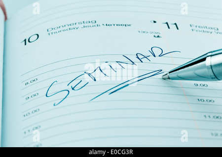 Un appuntamento viene messo giù in un calendario: Seminario, Ein Termin ist in einem Kalender eingetragen: seminario Foto Stock