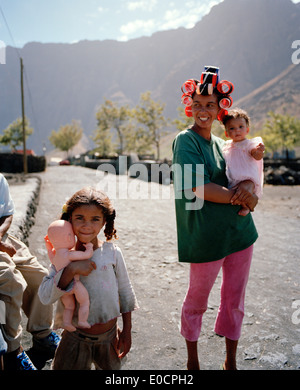 Donna con i bambini in piedi sul mainroad di Portela, Cha das Caldeiras, isola di Fogo, Ilhas do Sotavento, Repubblica del Capo Foto Stock