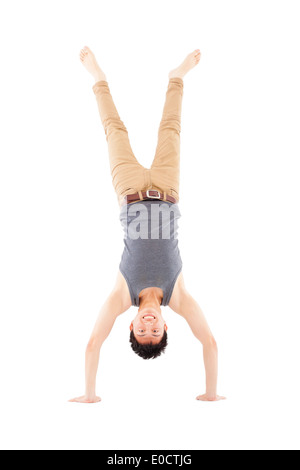 Giovane uomo facendo un handstand contro su sfondo bianco Foto Stock