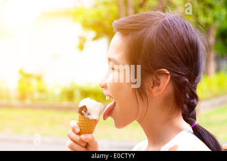 Felice bambina mangiare ghiaccioli con sfondo al tramonto Foto Stock