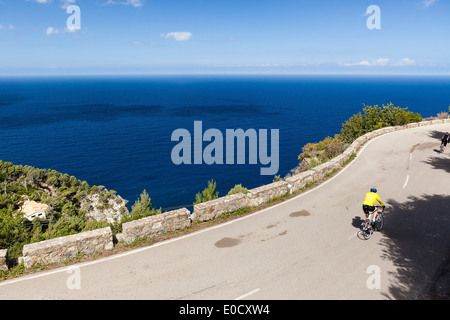 Bike racers su strada litorale affacciato sul Mar Mediterraneo, Banyalbufar, Mallorca, Spagna Foto Stock