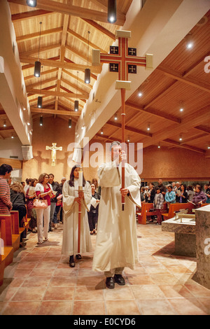 La Congregazione guarda come derubato ministranti portano candele e una croce come essi conducono una processione del Giovedì Santo a San Timoteo della Chiesa Cattolica, Laguna Niguel, CA. Foto Stock