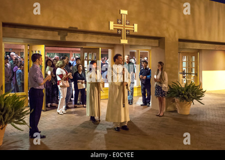 La Congregazione guarda come derubato ministranti portano candele e una croce come essi conducono una processione del Giovedì Santo a San Timoteo della Chiesa Cattolica, Laguna Niguel, CA. Foto Stock