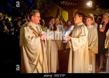 Il pastore derubato di San Timoteo della Chiesa Cattolica, Laguna Niguel, CA, legge dal vangelo accanto al fuoco di Pasqua all'inizio della grande Veglia Pasquale. Foto Stock