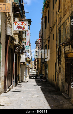 Una tipica strada stretta a La Valletta delimitata da case medievali e palazzi utilizzati per la moderna per il tempo libero. Foto Stock