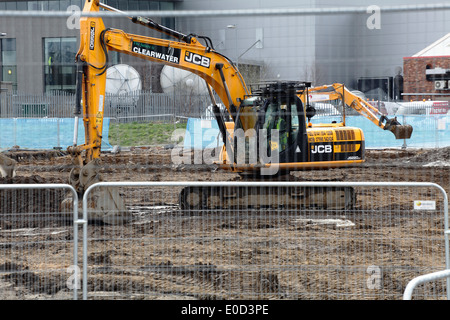 Scavatrice meccanica JCB che scavava terra in un cantiere, Scozia, Regno Unito Foto Stock