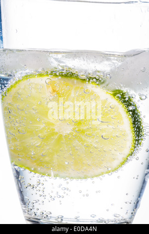 Con un bicchiere di acqua fresca da bere e un lime. Acqua minerale come un Durstloescher., Ein Glas mit frischem Trinkwasser und einer Lim Foto Stock