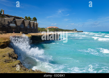La donna sta immagine di spruzzi delle onde in pietra lavica shore a Varadero Beach resort Cuba sull'Oceano Atlantico Foto Stock