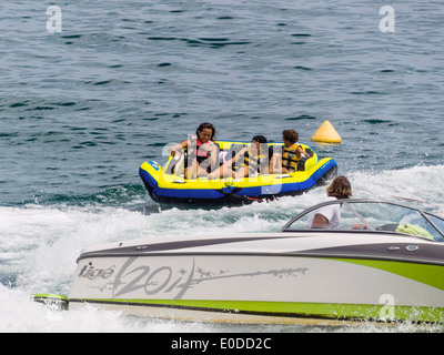 Vacanzieri in un gommone nel surf sono tirate in motoscafo., Urlauber in einem Schlauchboot in der Brandung werden von M Foto Stock